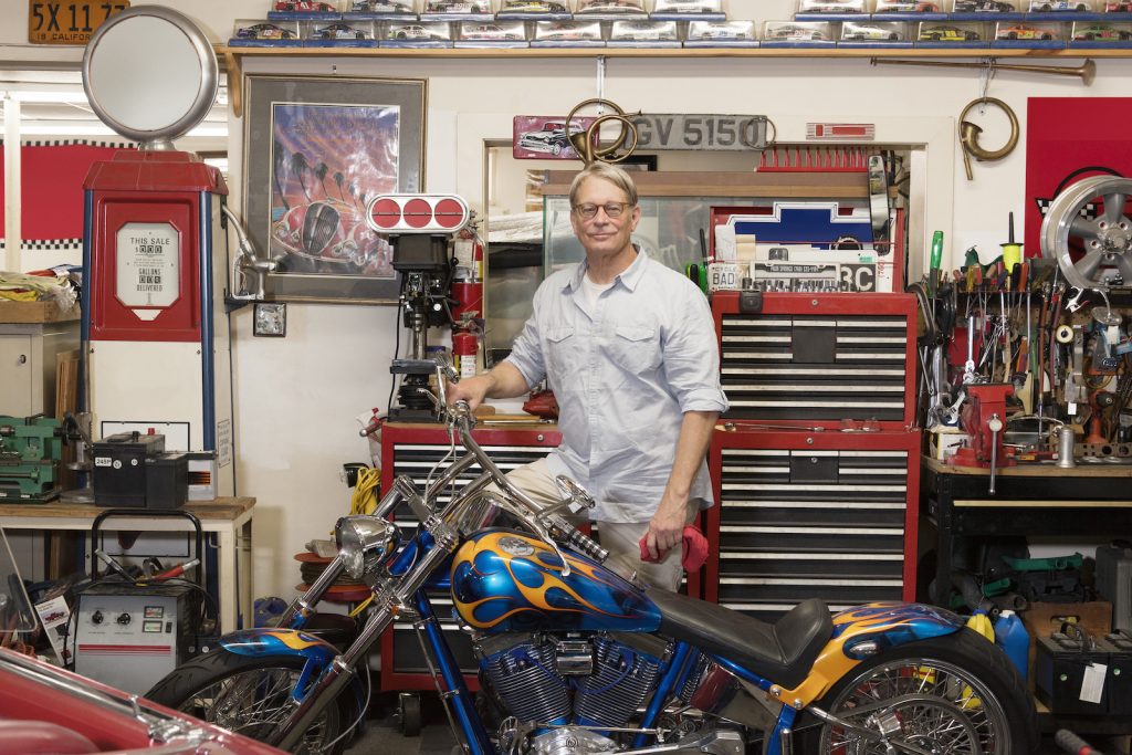 man at an motorcycle repair shop doing well. his small business must have a great website.